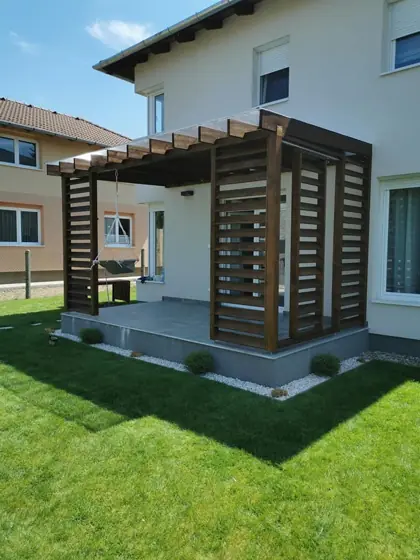 Sötétre pácolt pergola lamellás árnyékolóval a teraszon