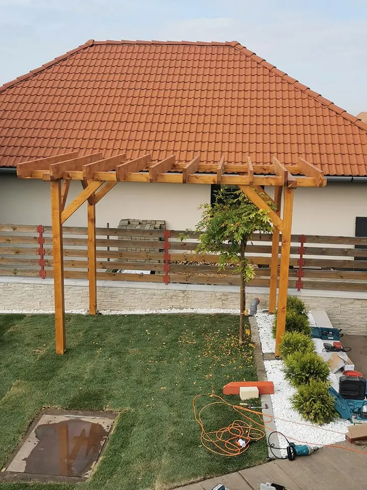 Fa pergola és hozzá illő fa kerítés a kertben